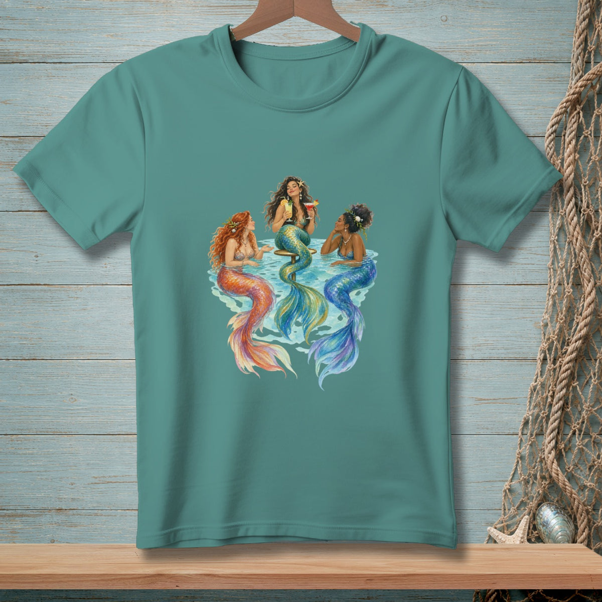 Three mermaids with colorful tails relax and drink cocktails in the water.