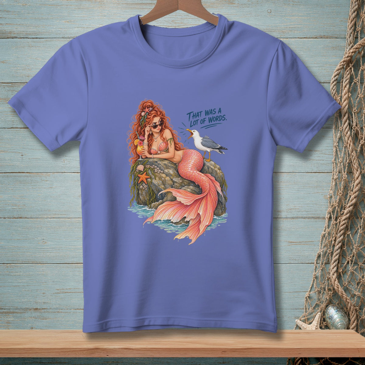 Mermaid with red hair and orange tail sits on a rock with a cocktail, a seagull, and text "That was a lot of words."