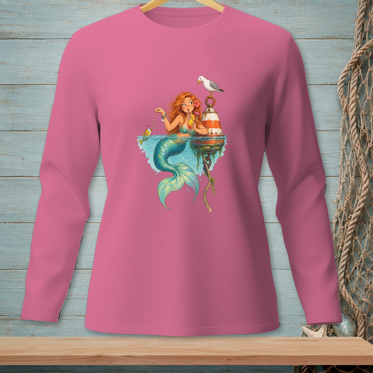 Pink long-sleeve shirt with a mermaid, fish, seagull, and buoy graphic.