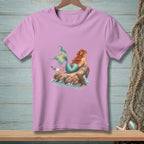 Pink t-shirt with graphic of a mermaid on a rock with a seagull.