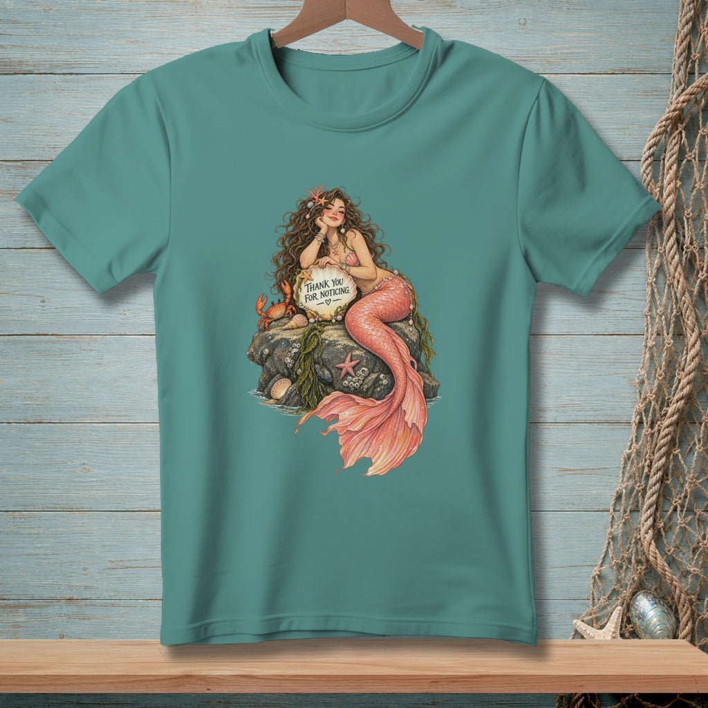Mermaid with crab and sign reading "Thank you for noticing" on a rock.