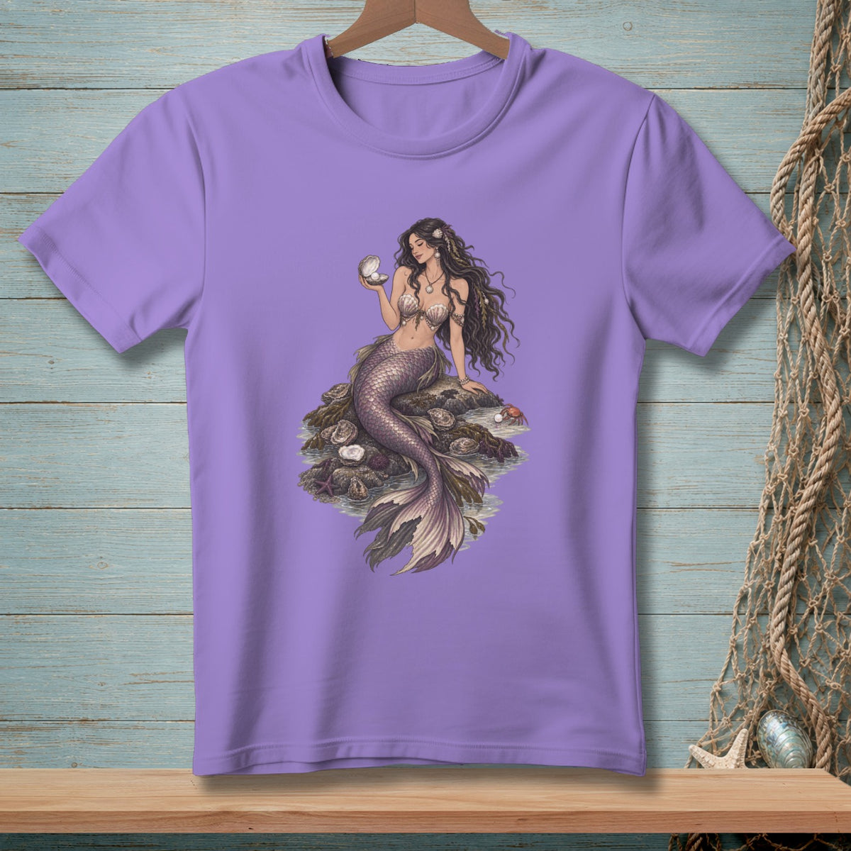 Purple t-shirt with a mermaid sitting on rocks holding a pearl.