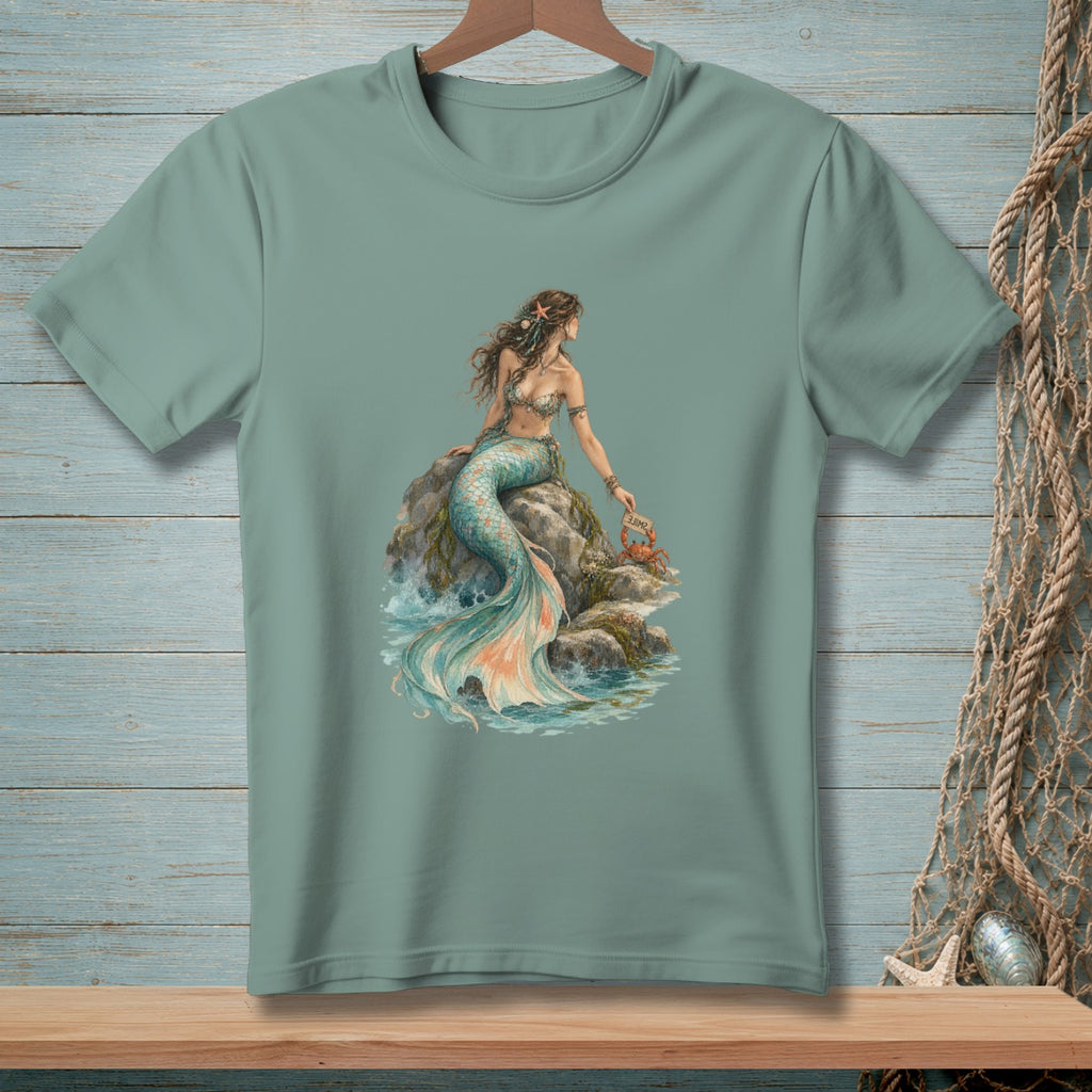 Teal t-shirt with a mermaid sitting on a rock holding a crab with a "Smile" sign.