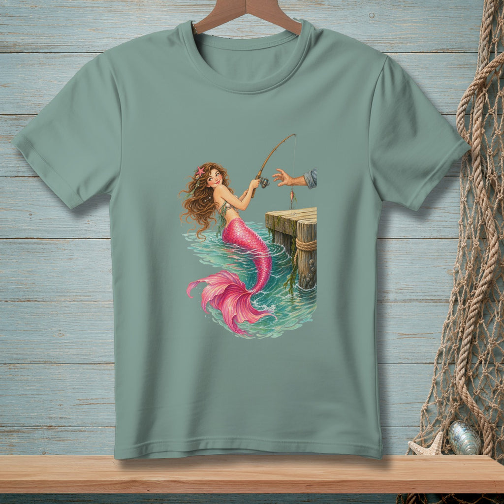 Green t-shirt with mermaid fishing from a dock with a bright pink tail.