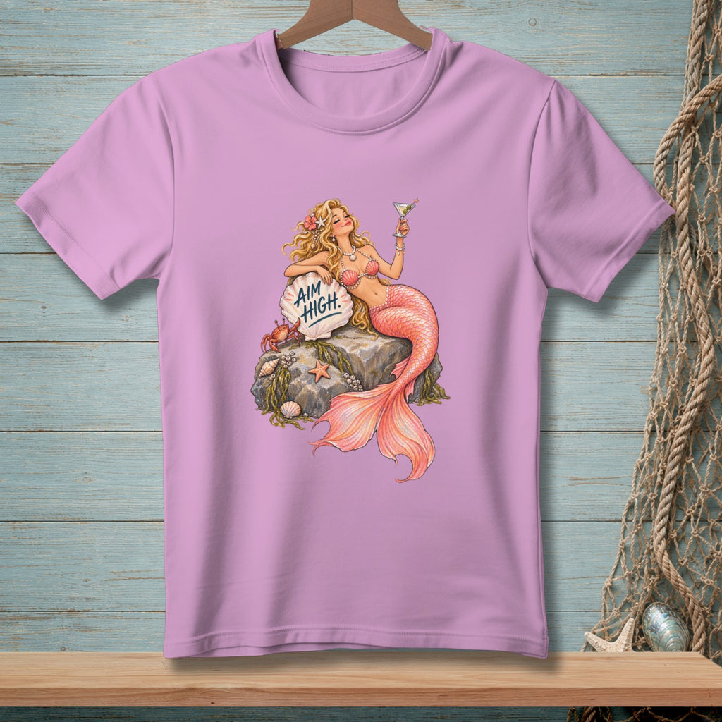 Pink t-shirt with mermaid graphic, holding a martini and a sign that says "Aim High."