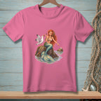Pink t-shirt with illustration of a mermaid and a seagull on a rock.