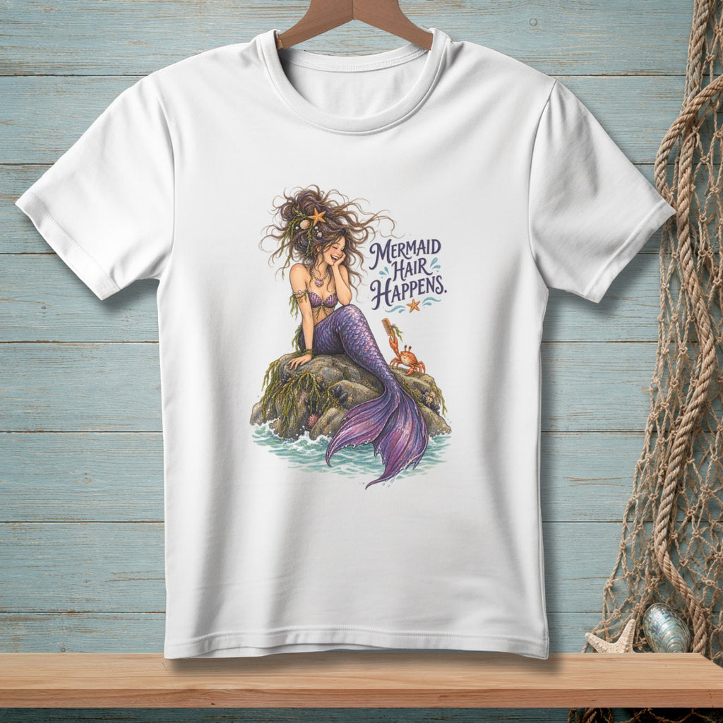 White t-shirt with a mermaid sitting on a rock, with text "Mermaid Hair Happens."