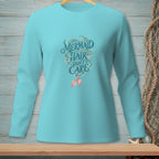 Long sleeve teal shirt with "Mermaid Hair Don't Care" text and mermaid tail graphic.
