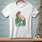 Mermaid on dock reading letter with crab and drink, watercolor style art.