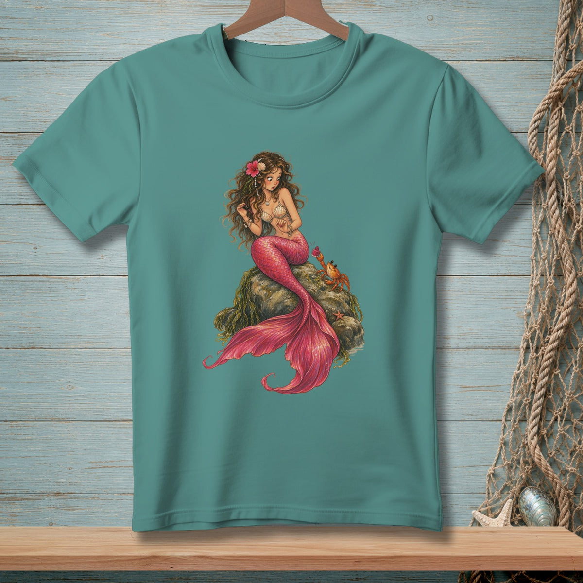 Teal t-shirt featuring a mermaid sitting on a rock with a crab.