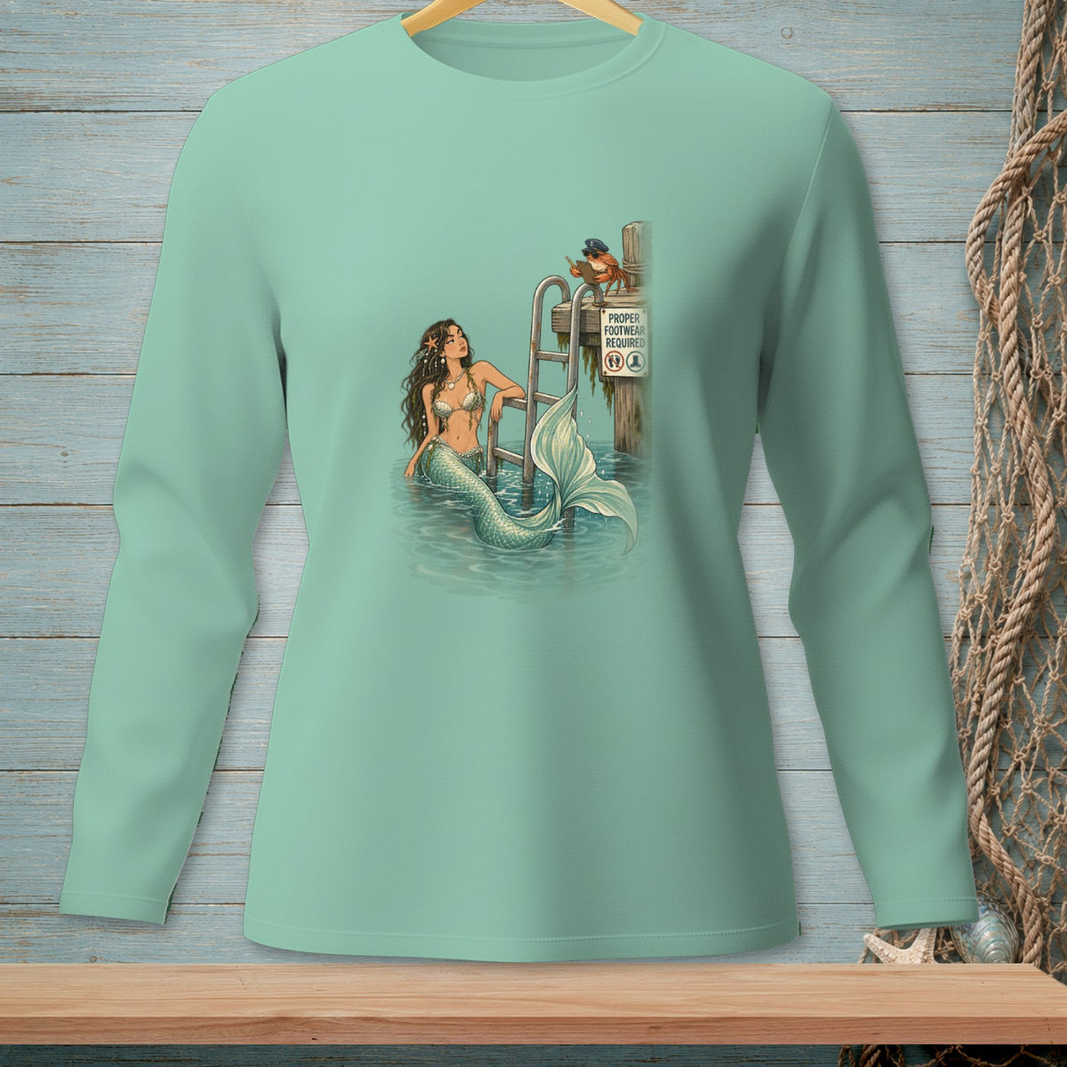 Mermaid lounging by ladder with crab on sign reading "Proper Footwear Required".