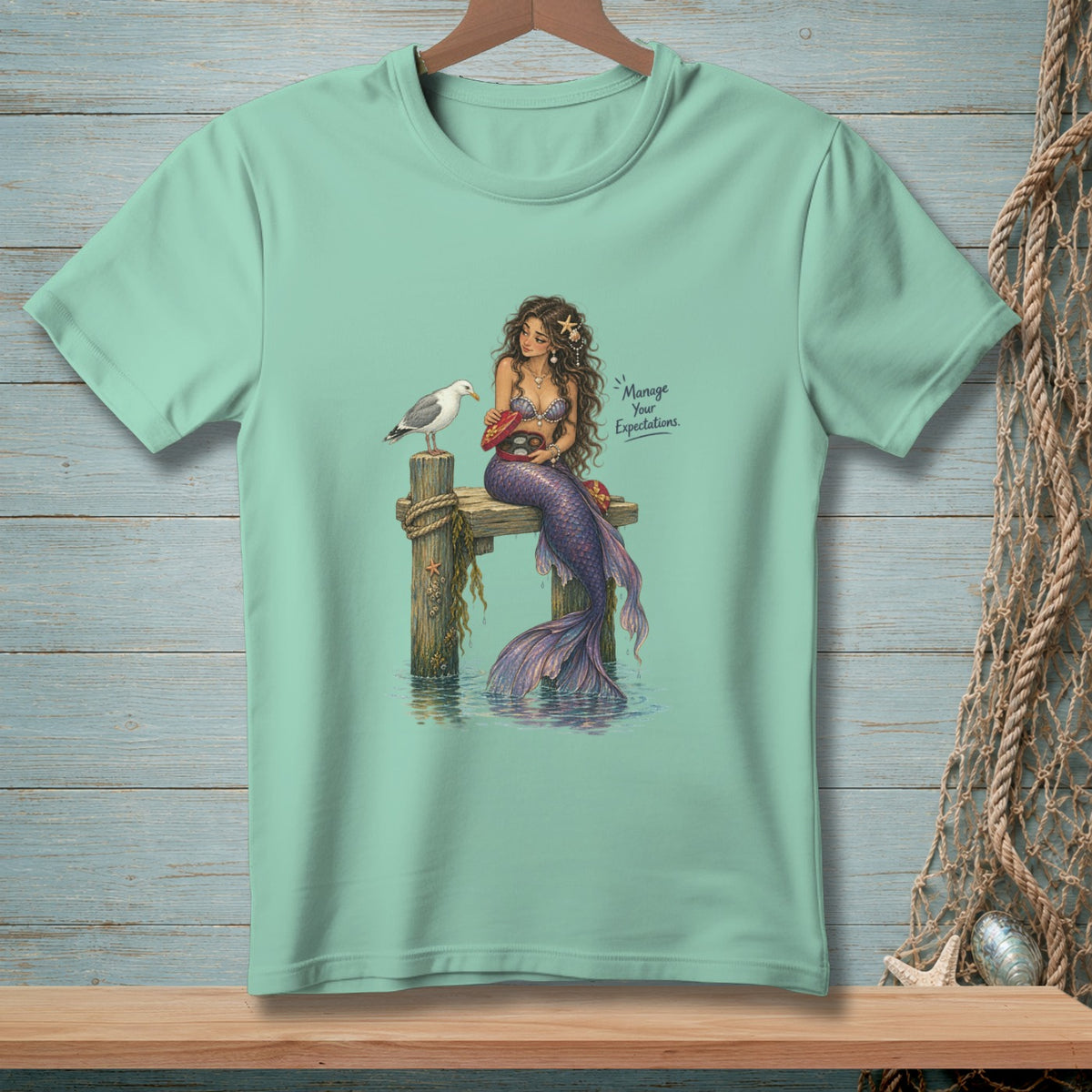 Mint t-shirt with a mermaid, seagull, and "Manage Your Expectations" text.