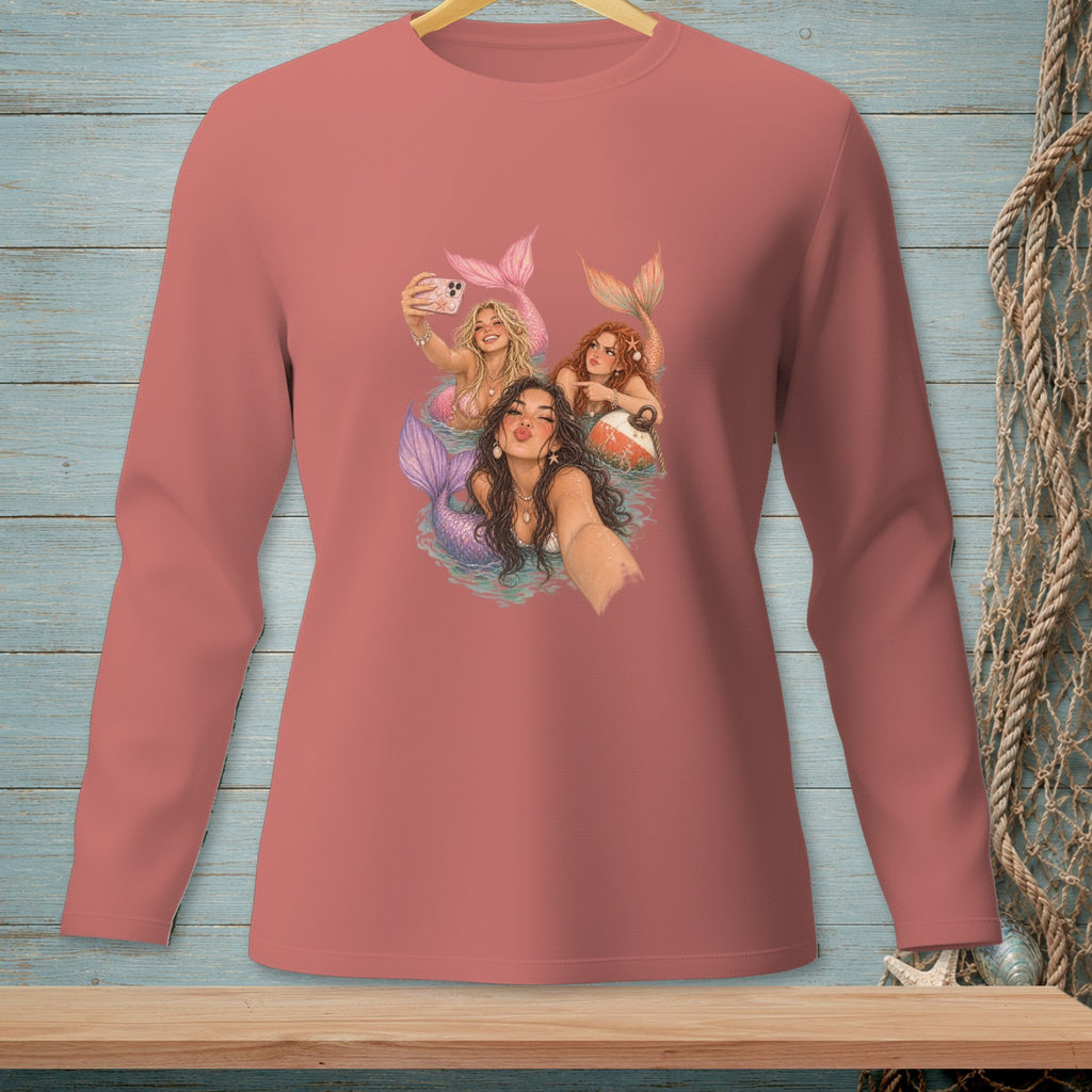 Three mermaids taking a selfie with colorful tails and seashell necklaces.