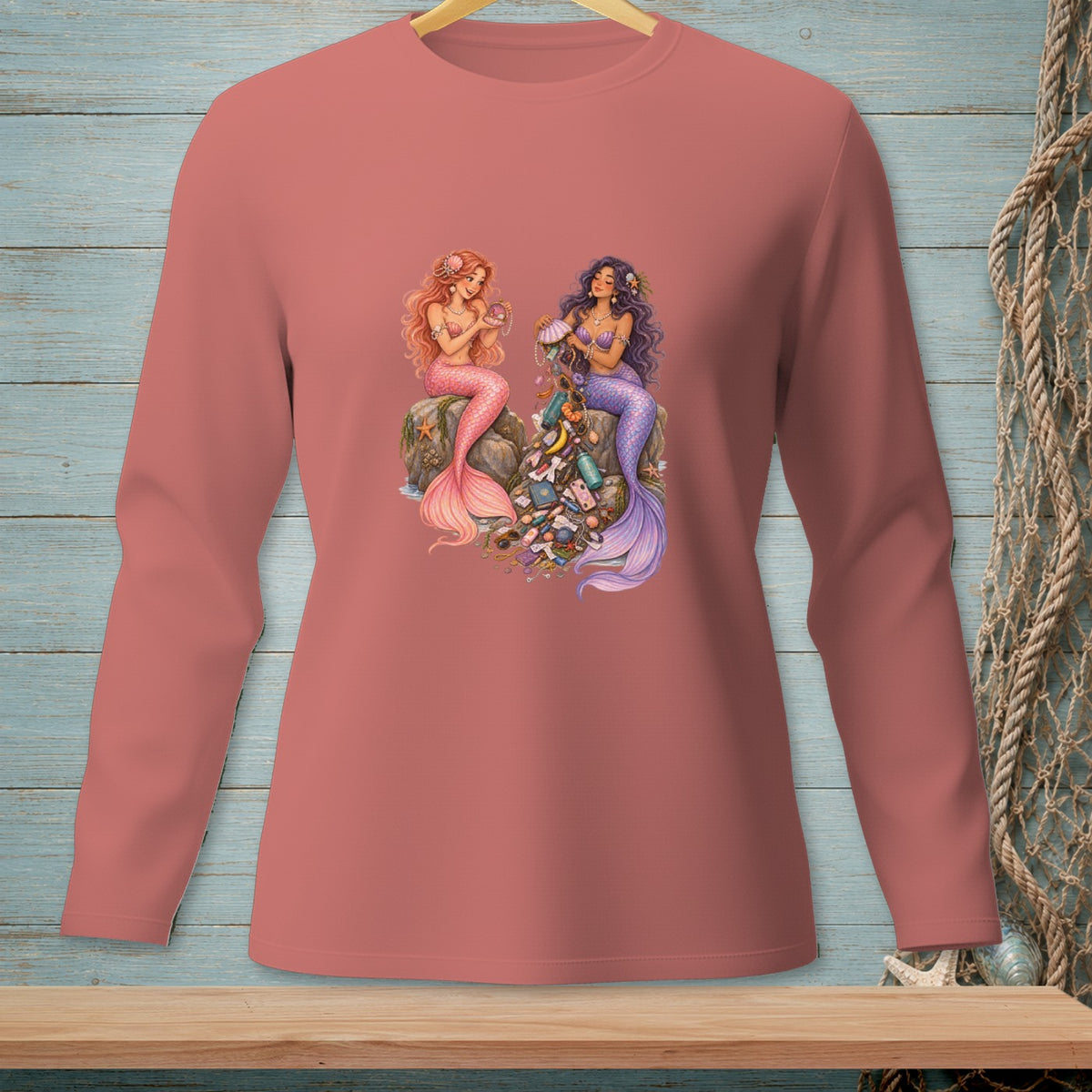 Two mermaids sit on rocks surrounded by collected treasures, one with pink tail, the other with purple.