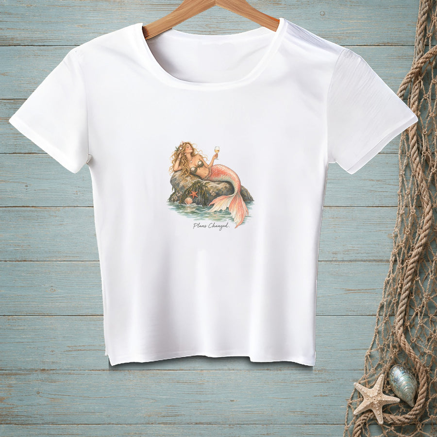 White t-shirt with a mermaid holding a glass of champagne, text "Plans Changed".