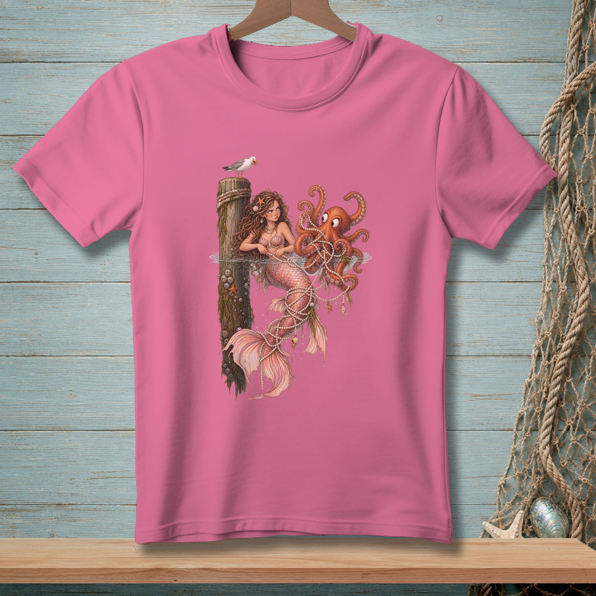 Pink t-shirt with mermaid and octopus graphic, featuring a seagull on a post.