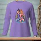Two mermaids with colorful tails sit on a dock, looking at a phone.