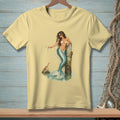 Pale yellow t-shirt with a mermaid holding a martini glass and a crab on a rock.