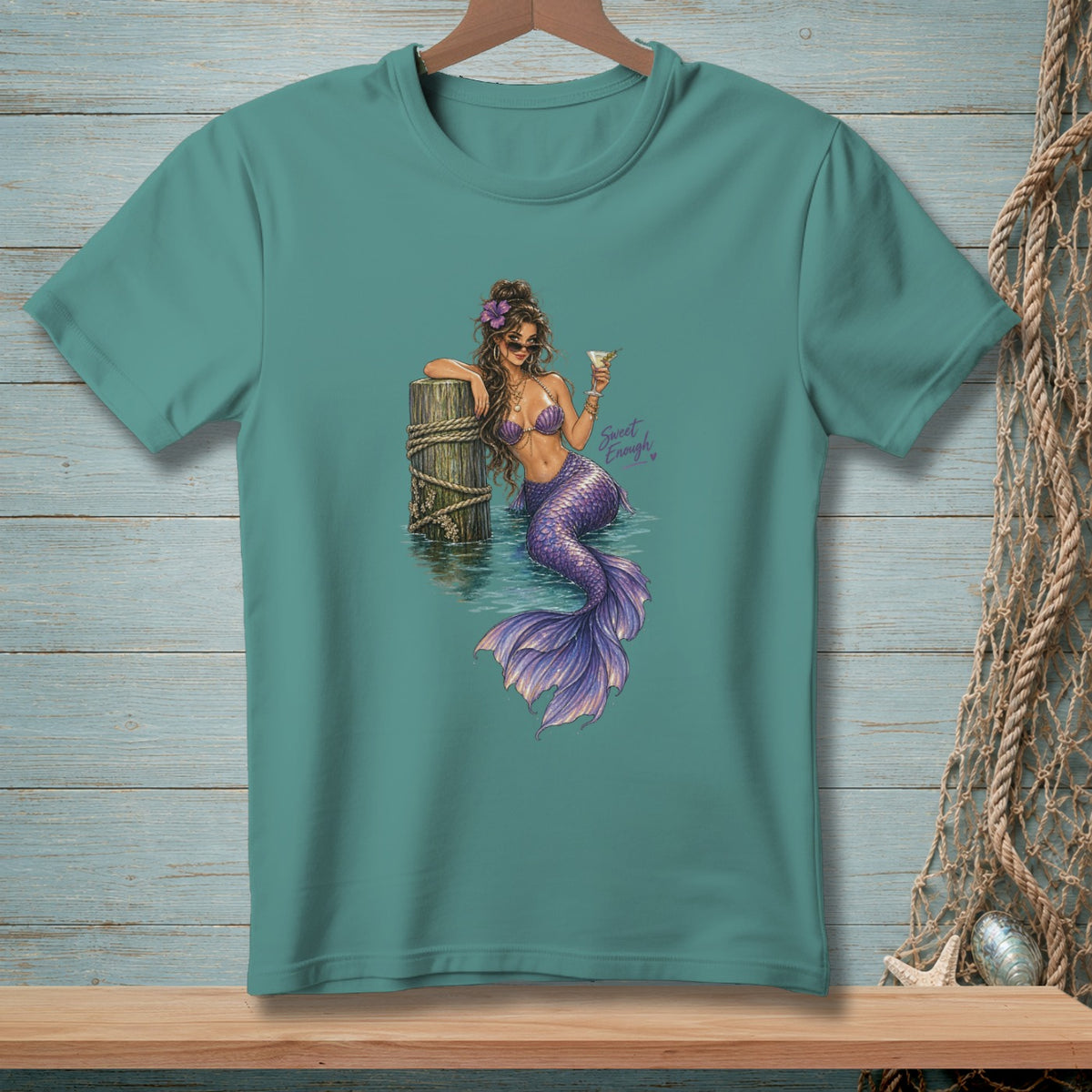 Teal t-shirt with a mermaid wearing sunglasses and holding a martini.