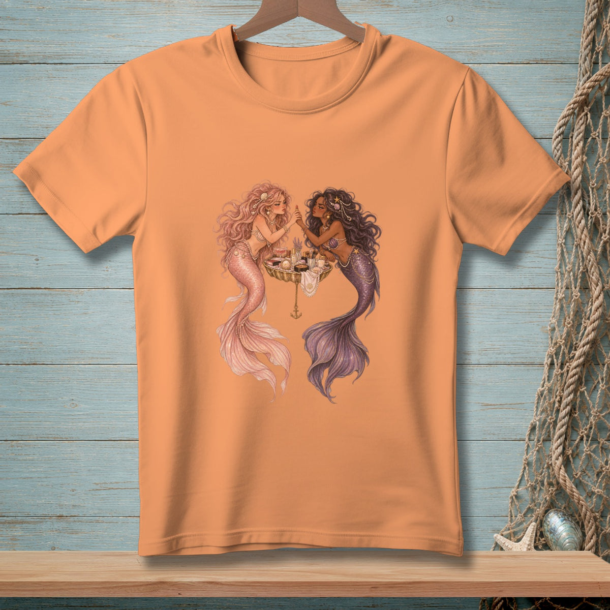 Two mermaids with tails apply makeup at a shell table.