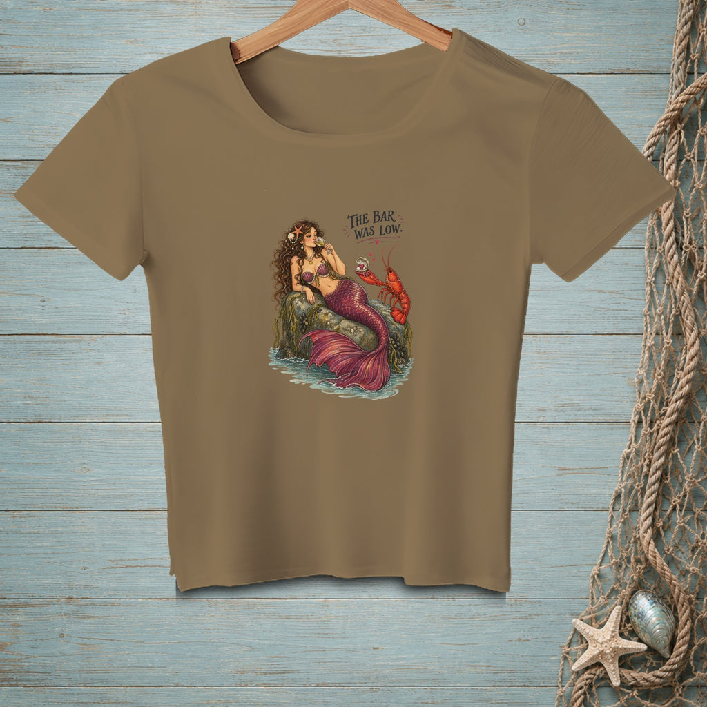 A mermaid sits on a rock with a lobster, text says "The Bar Was Low."