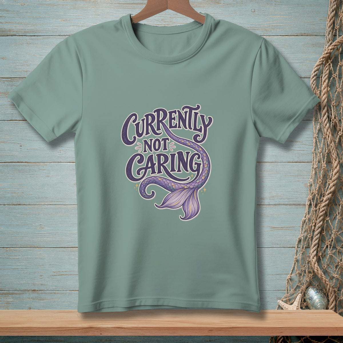 T-shirt with "Currently Not Caring" text and purple mermaid tail design.