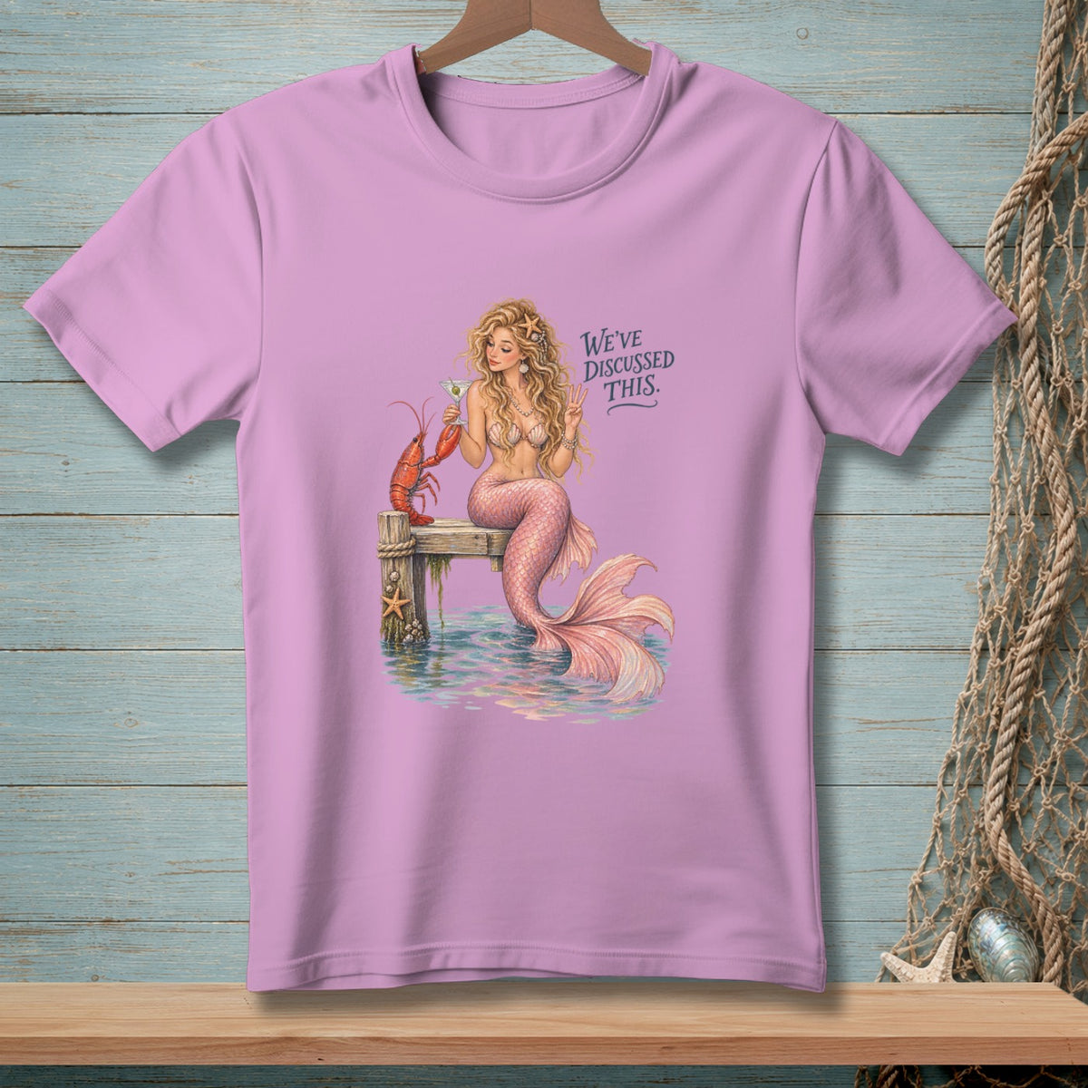 Mermaid with lobster and drink on dock, text "WE'VE DISCUSSED THIS."