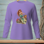 Illustration of a mermaid on a rock with a crab and picnic basket on a purple long-sleeved shirt.