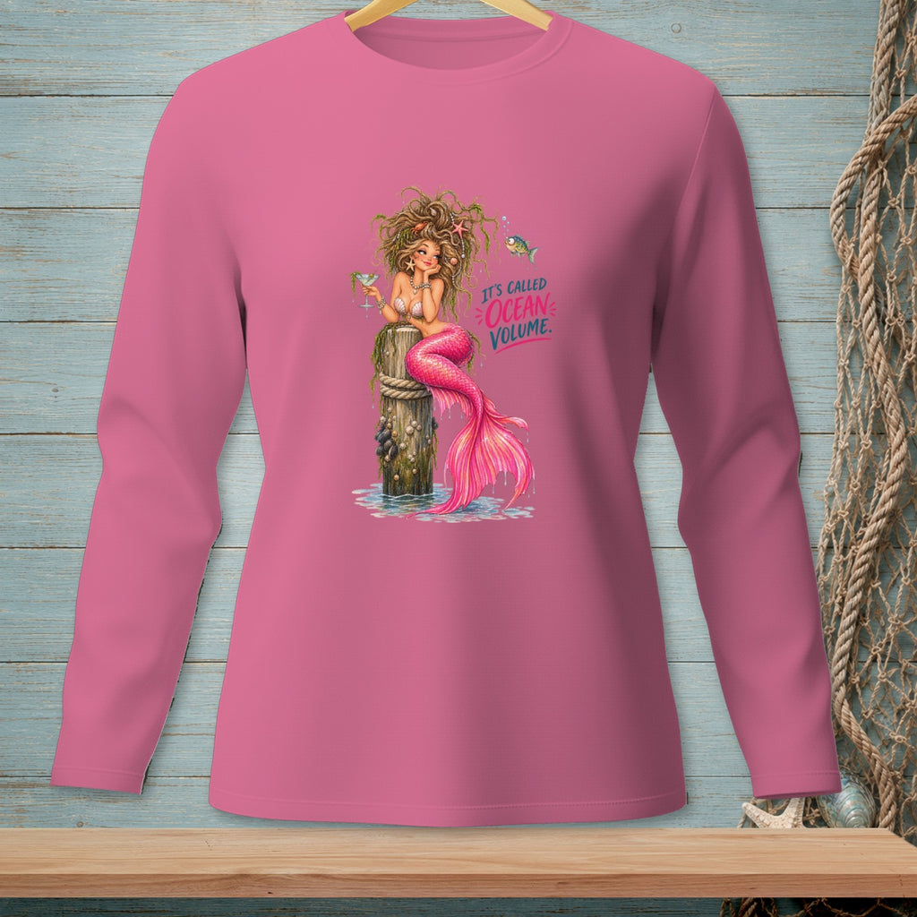 Pink long-sleeve shirt with a mermaid sitting on a post and text reading "IT'S CALLED OCEAN VOLUME."
