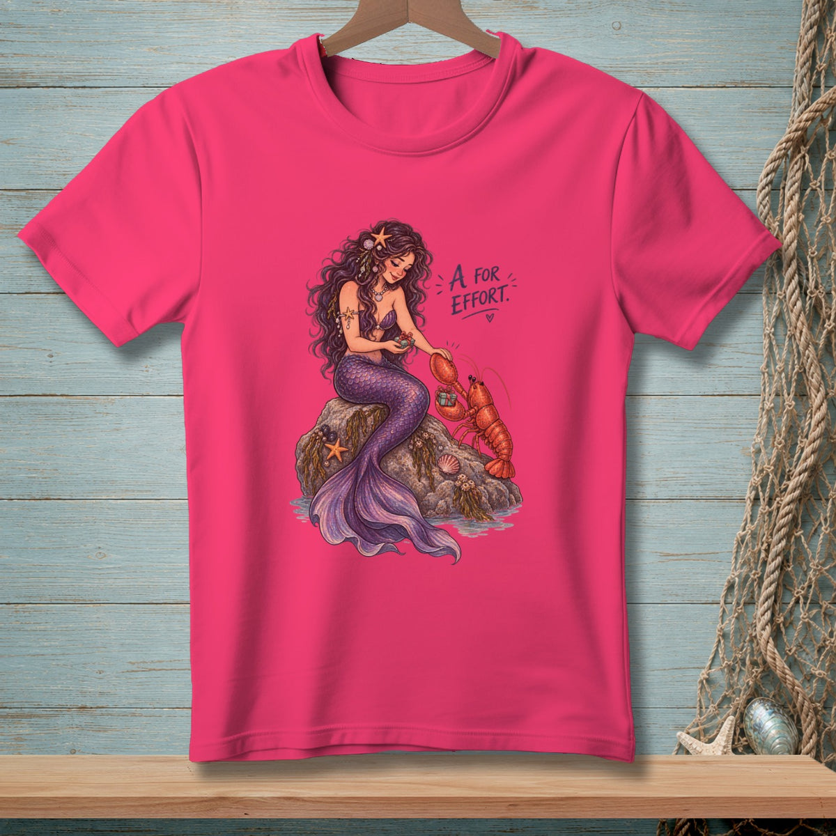 Mermaid interacting with a lobster on a rock, text "A FOR EFFORT"