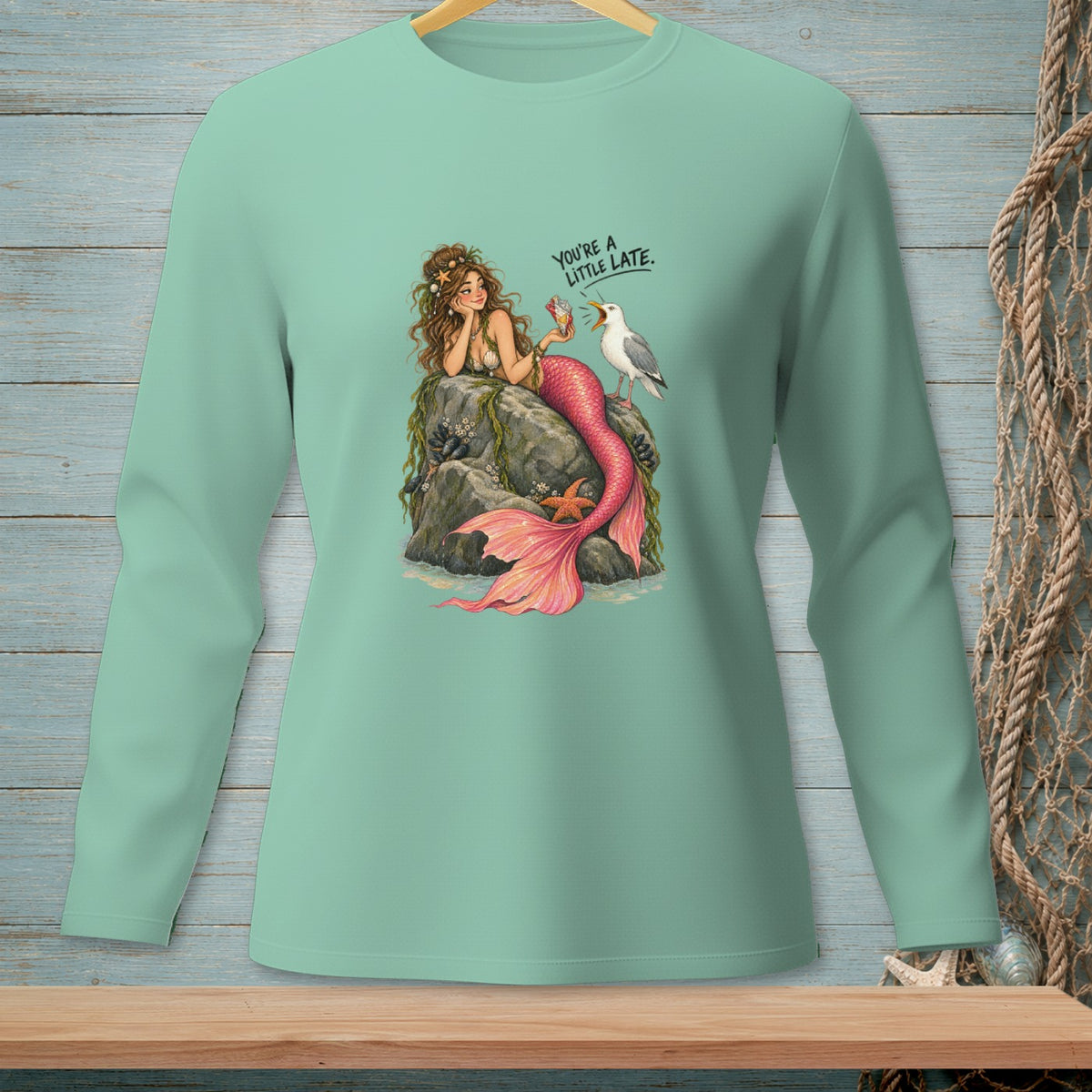 Mint green long-sleeve shirt with mermaid and seagull art, reads "You're a little late."