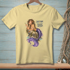 Light yellow t-shirt with mermaid art and text "Salty Hair. Saltier Attitude."
