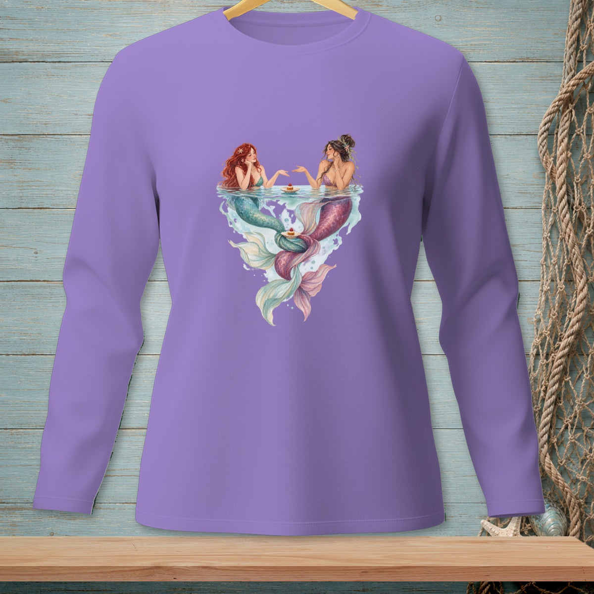 Two mermaids in water with cakes, printed on a purple long-sleeve shirt.