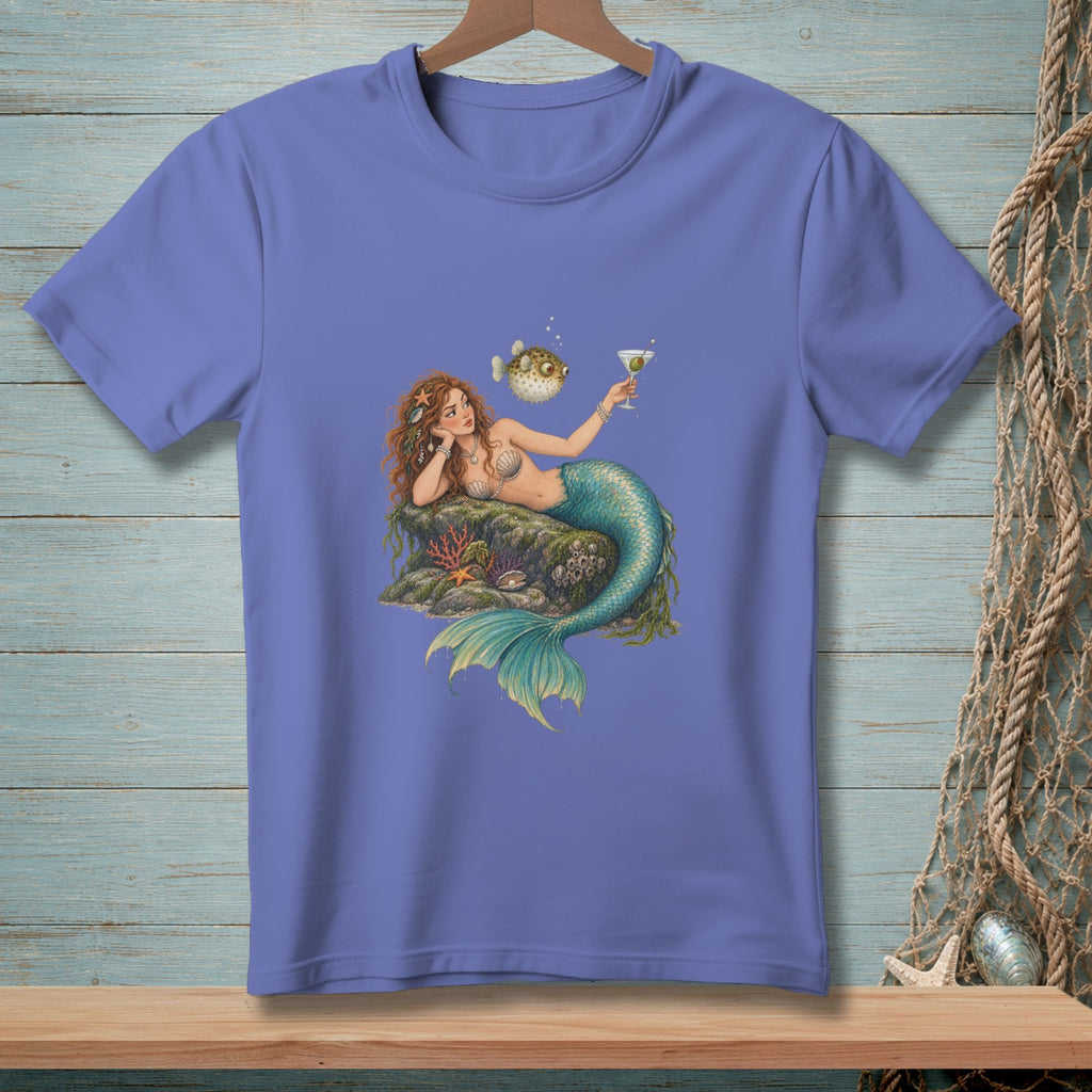 Mermaid holding a martini glass with a pufferfish on a rock surrounded by coral.
