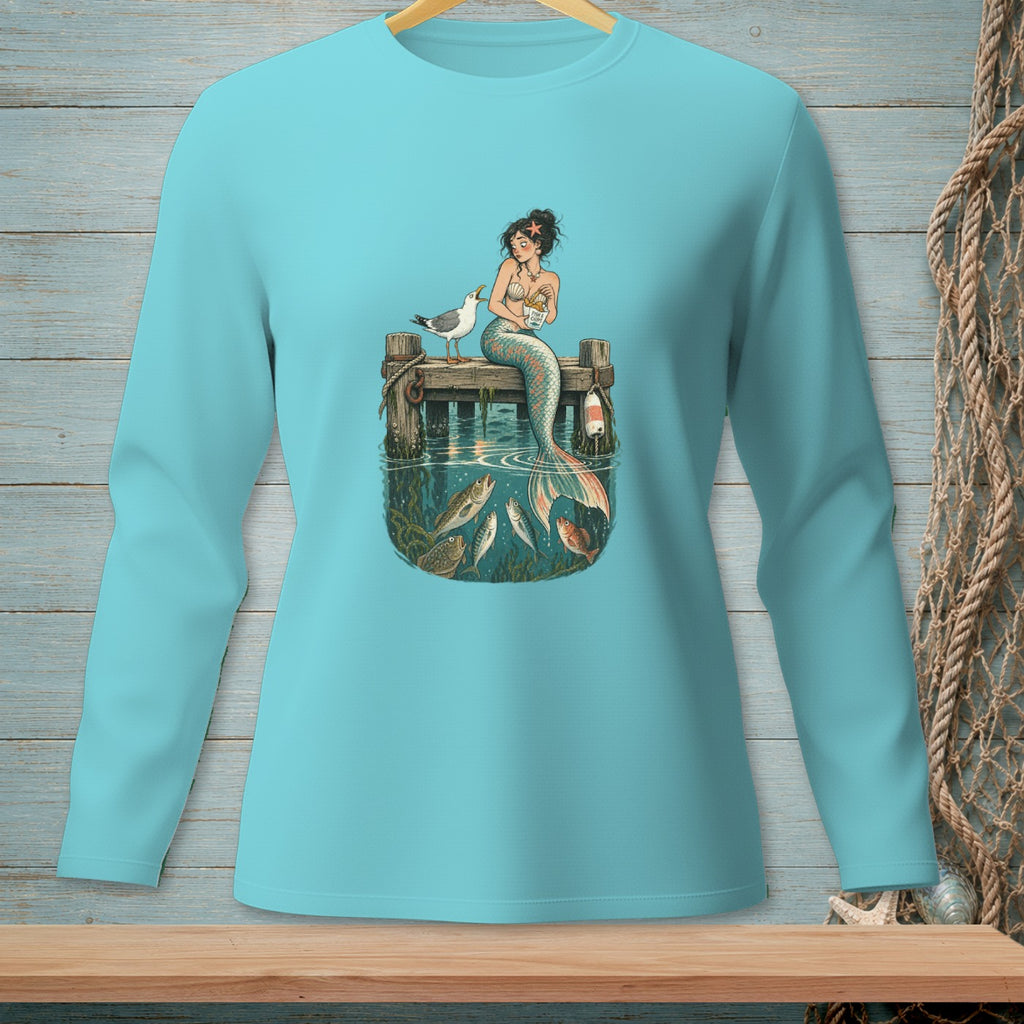 Mermaid sitting on pier with fish and seagull, blue long-sleeve shirt.