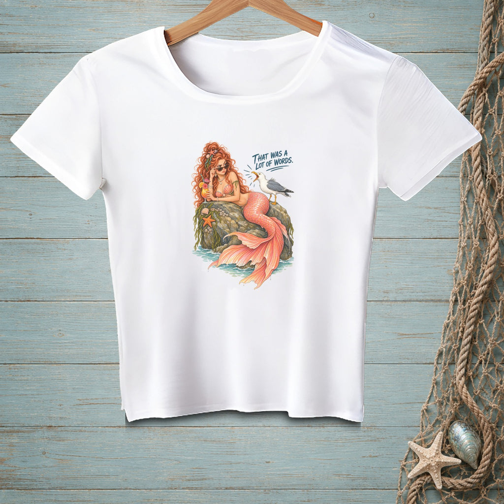 White t-shirt with a cartoon mermaid and seagull graphic that says "THAT WAS A LOT OF WORDS."