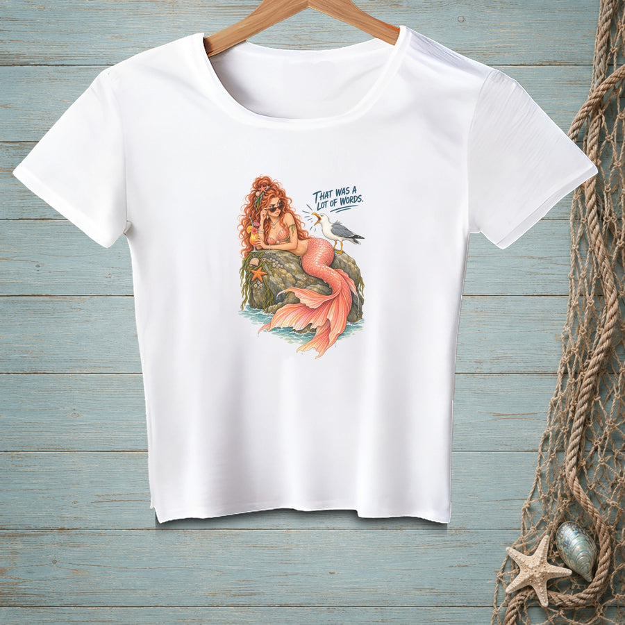 White t-shirt with a cartoon mermaid and seagull graphic that says "THAT WAS A LOT OF WORDS."