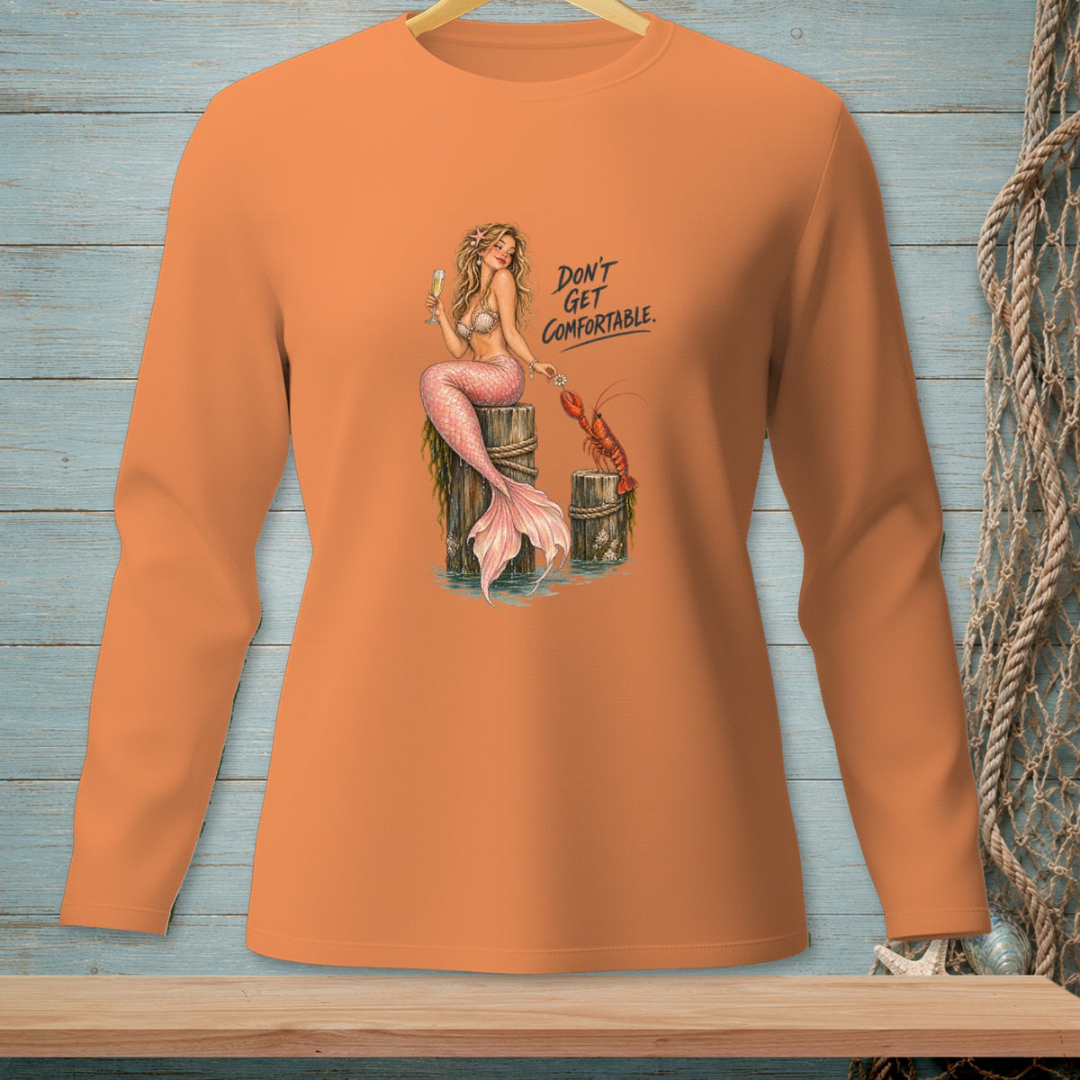 Long sleeve orange shirt with mermaid, lobster, and text "Don't Get Comfortable."