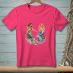 Two mermaids sit on rocks, one reaching towards the other with blue and green tails.