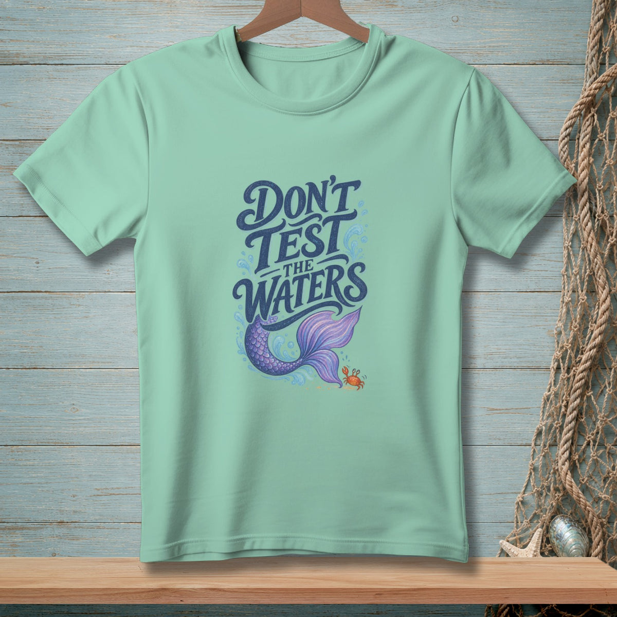 Light mint t-shirt with "Don't Test The Waters" text, mermaid tail, and crab graphic.