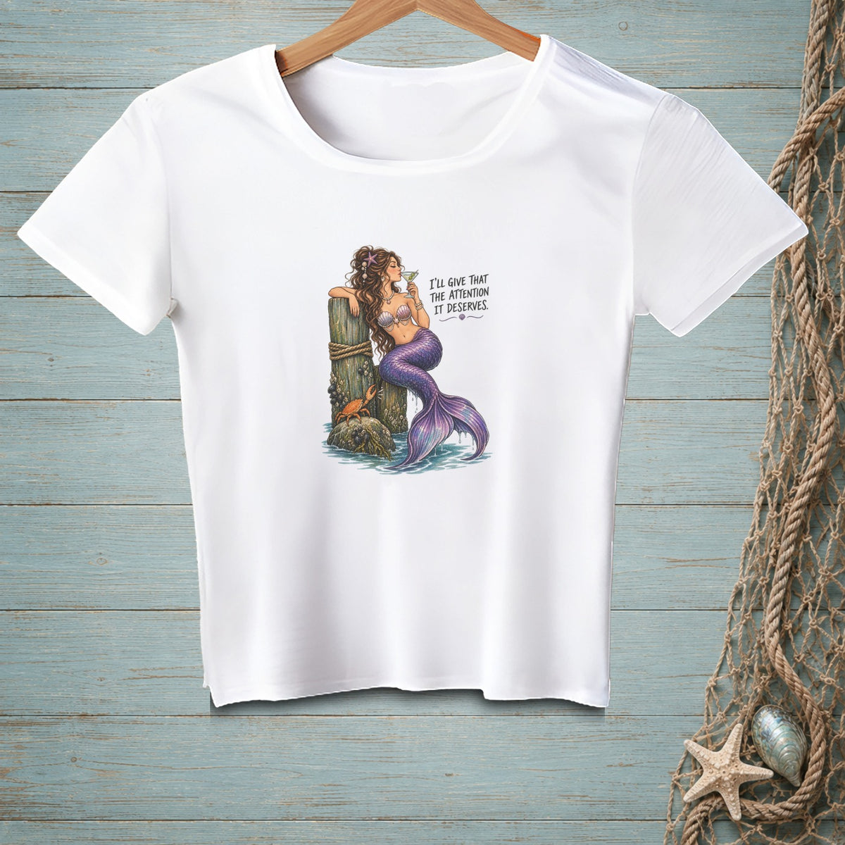 White t-shirt with a graphic of a mermaid holding a drink, with text.