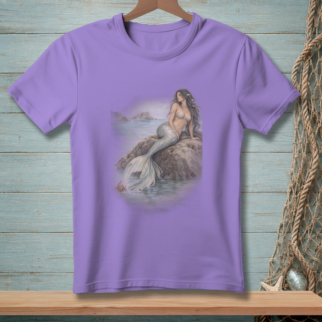 Purple t-shirt with a print of a mermaid sitting on a rock by the sea.