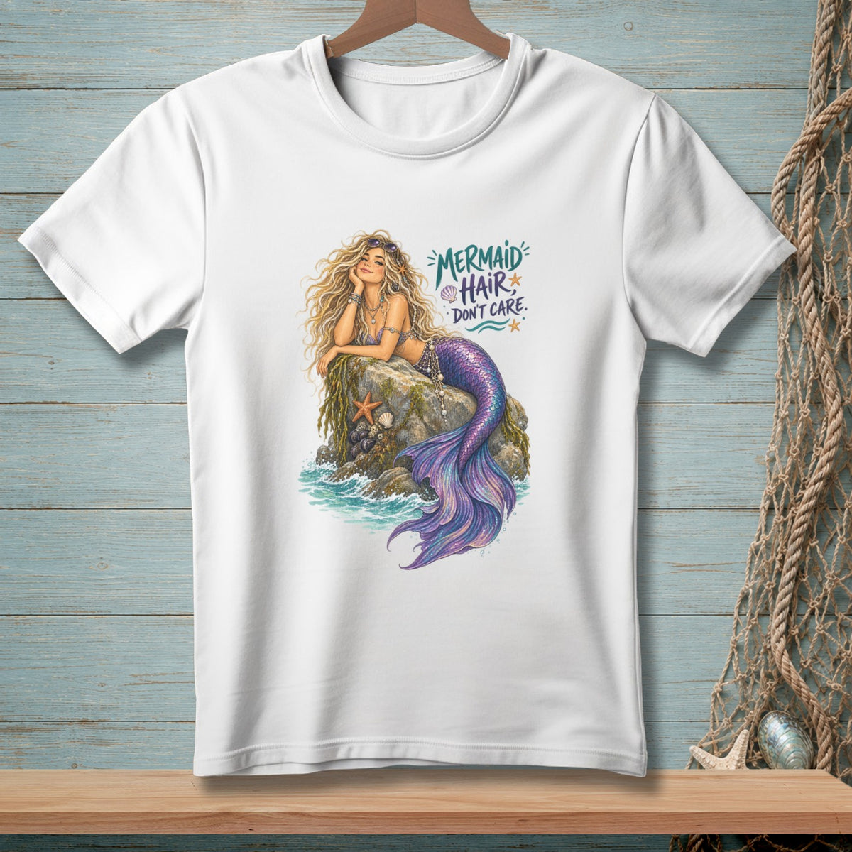 White t-shirt with a mermaid lounging on a rock, "Mermaid Hair Don't Care" text.