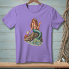 Mermaid with cocktail on rock with crab and seashells, printed on a purple t-shirt.