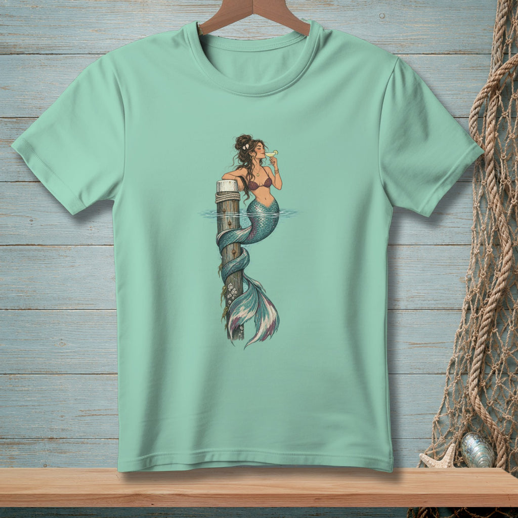 Mermaid with a drink wraps around a wooden post in the water.