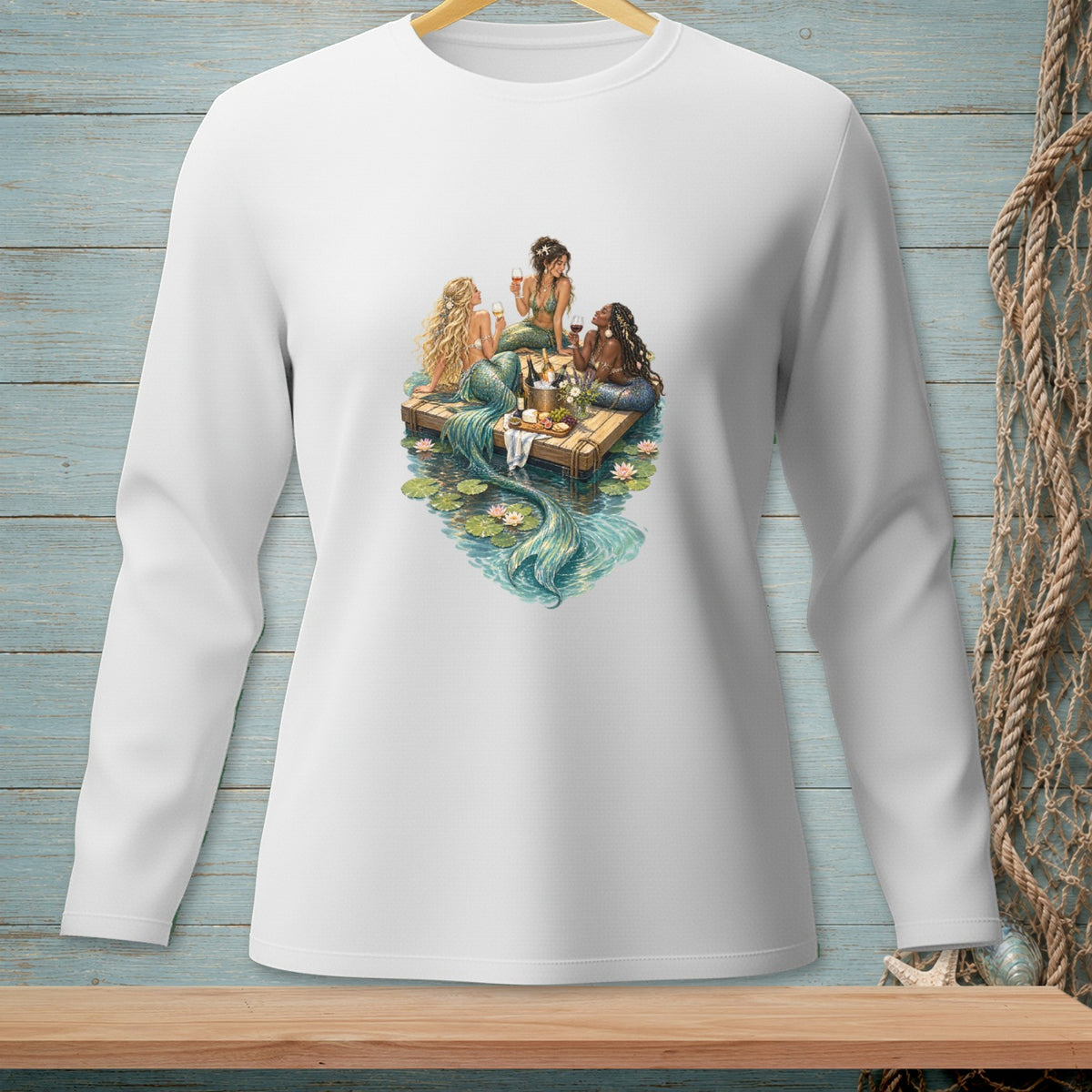 Three mermaids with flowing tails sit on a raft, enjoying drinks and snacks.