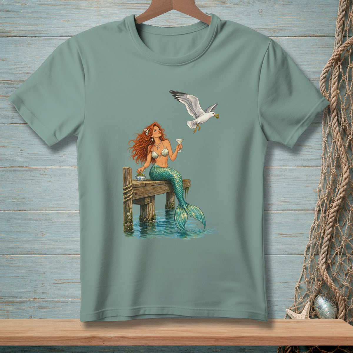 Mermaid with red hair sitting on a dock with a seagull holding food.