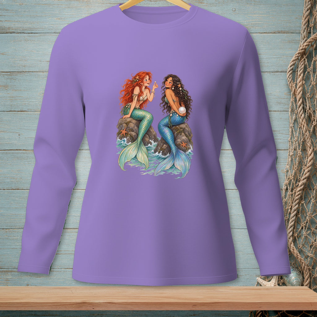 Two mermaids, one with red hair, the other with dark hair, sit on rocks.