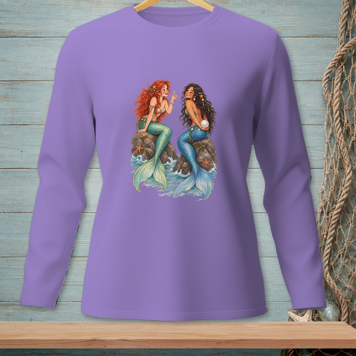 Two mermaids, one with red hair, the other with dark hair, sit on rocks.