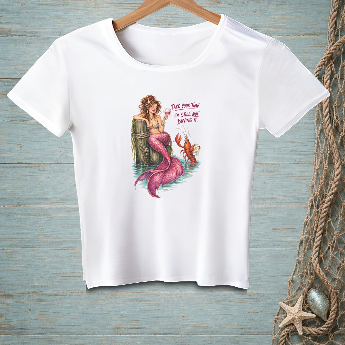 White t-shirt with mermaid and lobster graphic and text: "Take your time. I'm still not buying it."